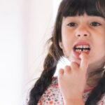 A young girl looking at herself after losing her front tooth