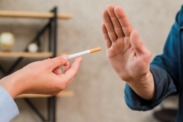 man refusing an offer to smoke by a showing disapproval through his hand