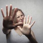Woman with a toothache in gray top looking frightened