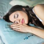 A woman sleeping comfortably with her hand on the pillow