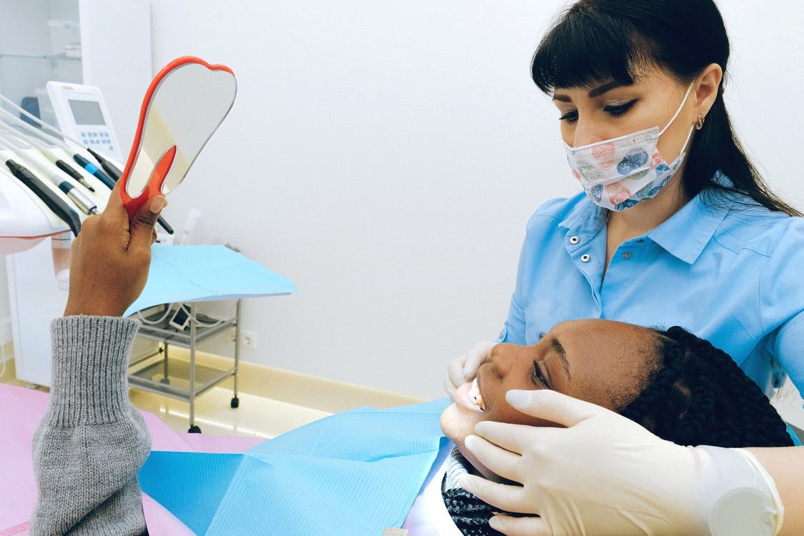A patient looking at her teeth after a dental procedure