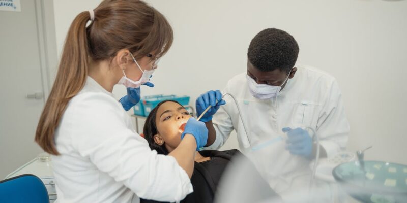 Dentist performing root canal surgery on her patient