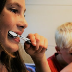 A mother and her kid brushing teeth together