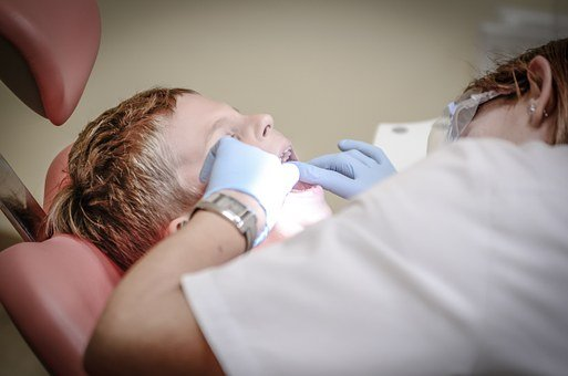A picture of a dentist examining their patient's teeth