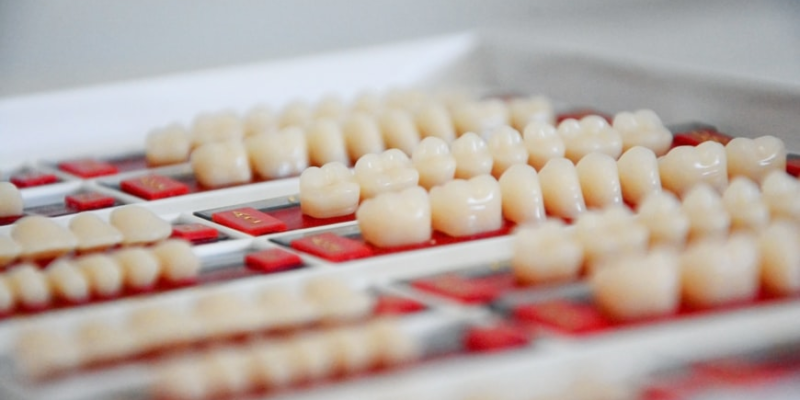 Several dental crowns on a tray